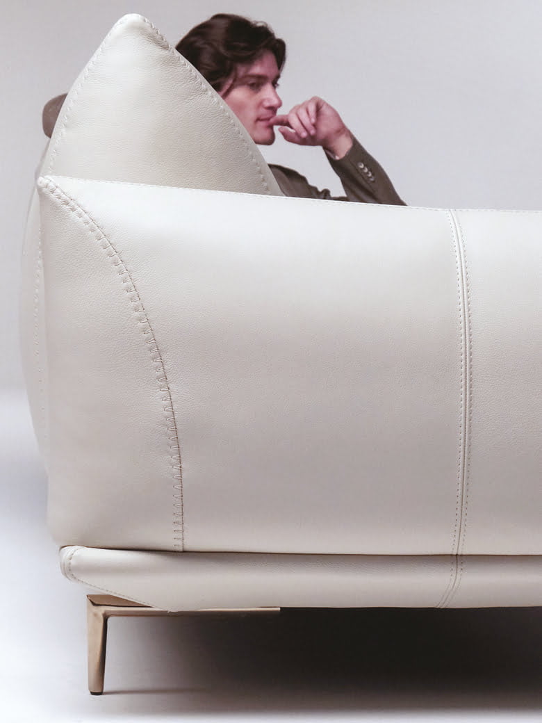 Elegant sectional with heightened backrests for superior comfort, minimal base, and decorative stitching, combining sophistication with supported relaxation. | Dragées by Calia Italia