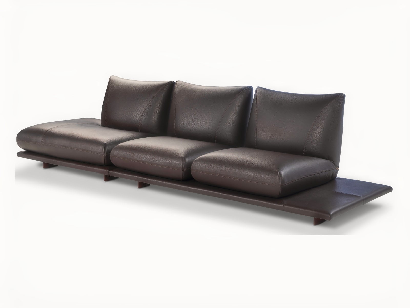 Modular 'Pralin' sofa with removable elements, wooden feet, and versatile configurations, including a day bed and integrated table, ensures customizable comfort and relaxation. | Pralin by Calia Italia