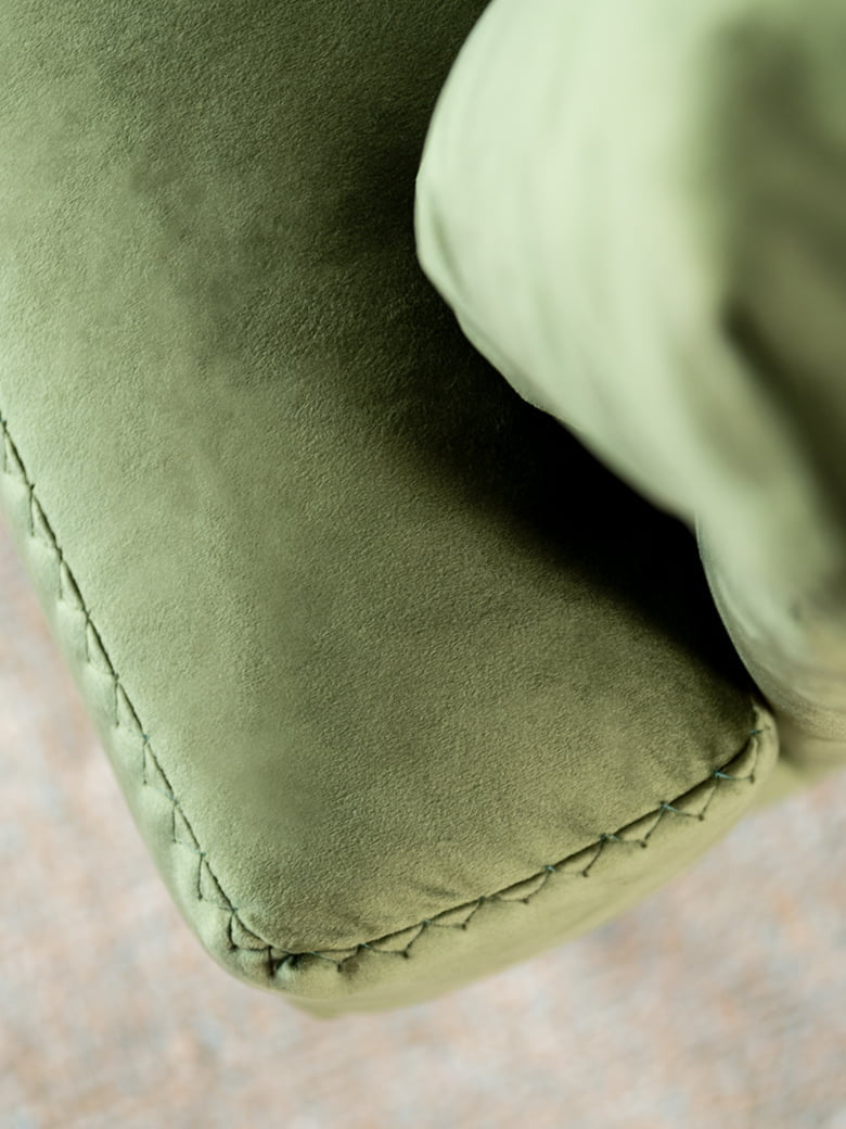Elegant Fleur chair with stylish pin-shaped legs and sophisticated stitches, ideal for both snug homes and professional spaces, offering comfort in compact form with option for leather or removable fabric. | Fleur by Calia Italia