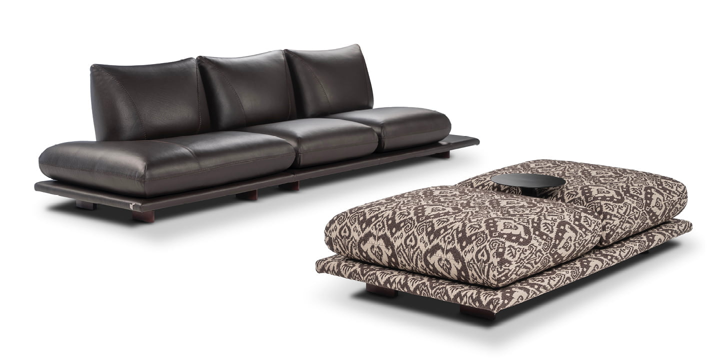 Modular 'Pralin' sofa with removable elements, wooden feet, and versatile configurations, including a day bed and integrated table, ensures customizable comfort and relaxation. | Pralin by Calia Italia